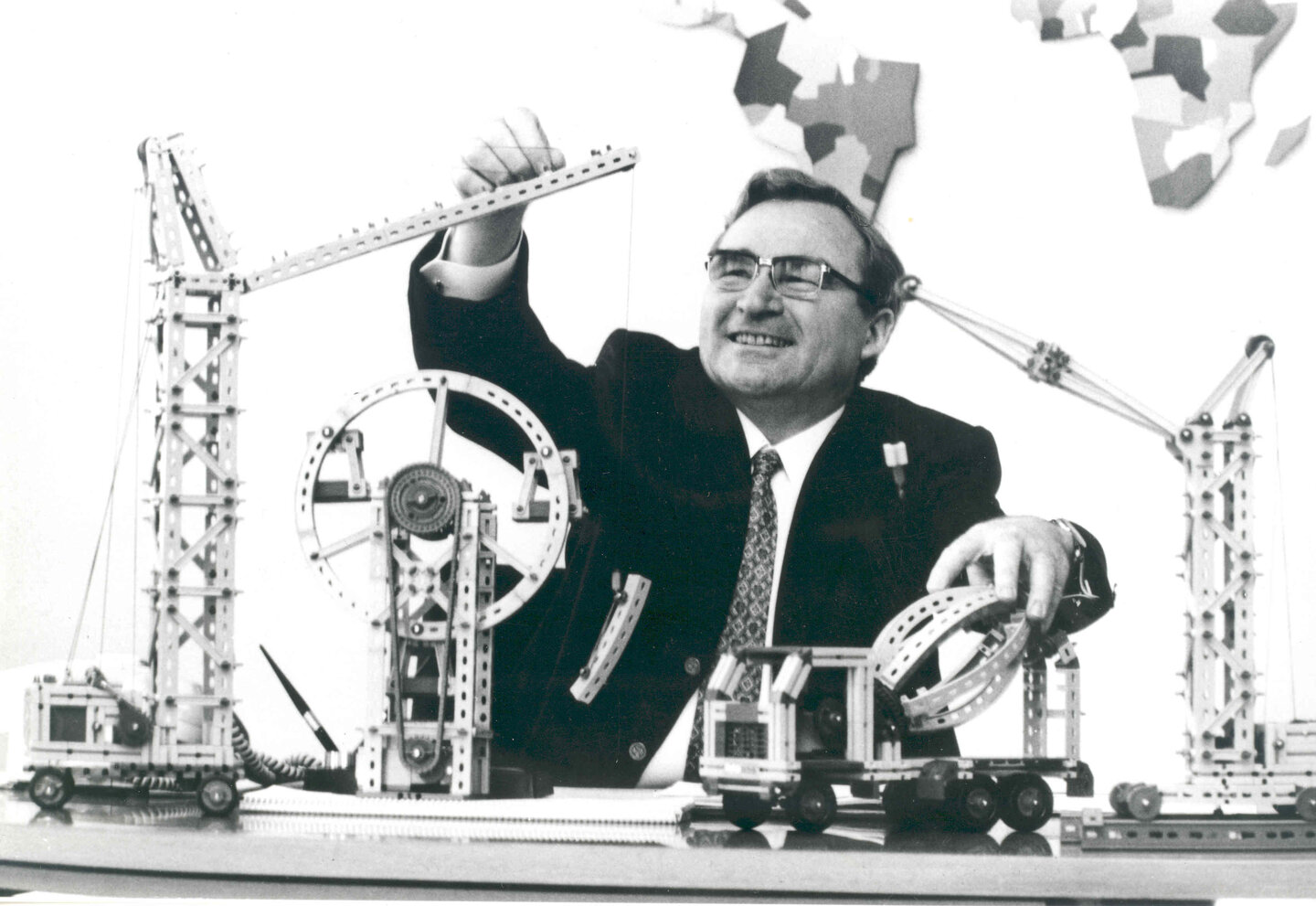 Artur Fischer, ein Mann mittleren Alters mit Brille, ein Erfinder, mit verschiedenen technischen Geräten und Konstruktionen, die er erfunden hat.