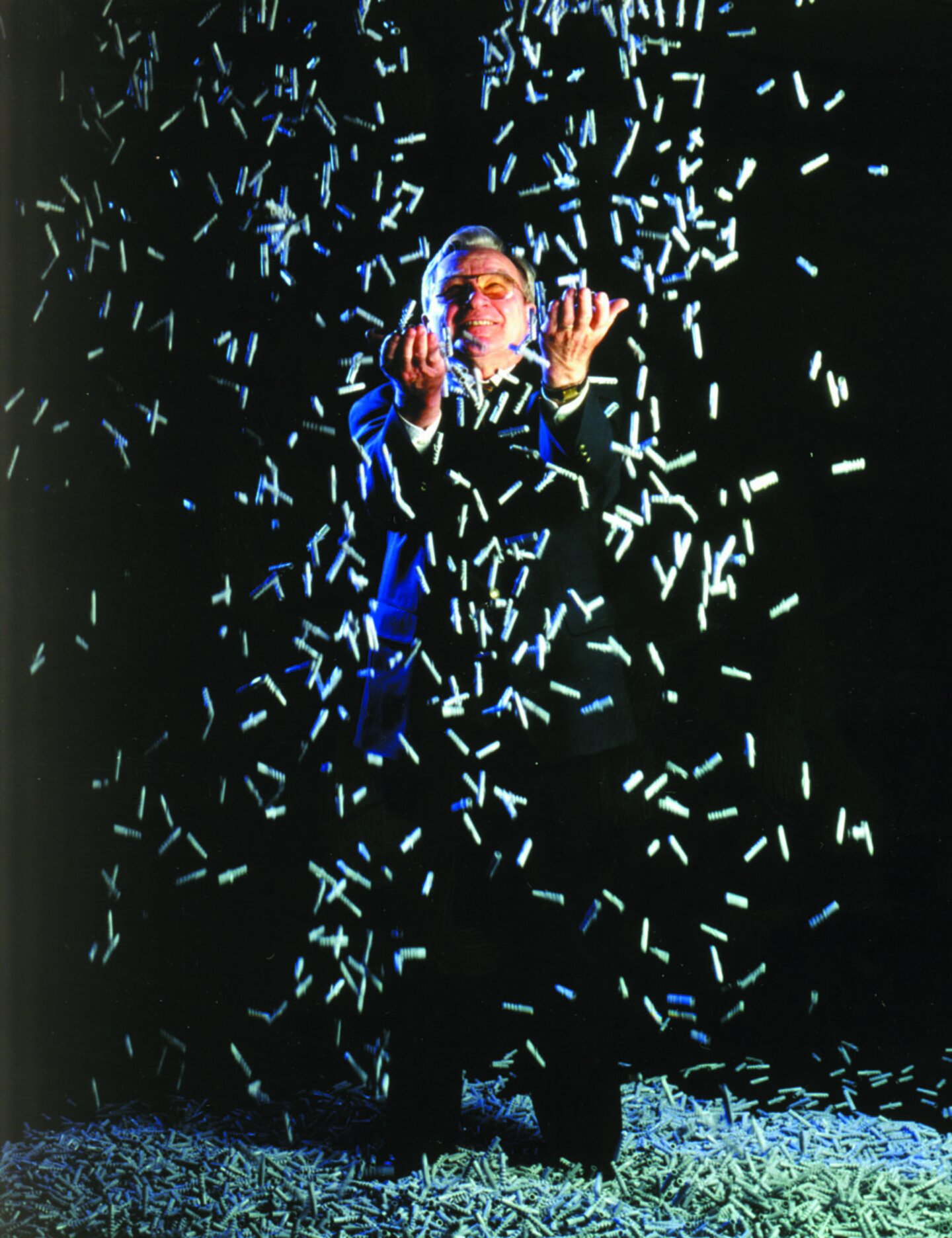 Der Erfinder Artur Fischer wirft sehr viele Dübel wie Konfetti in die Luft.